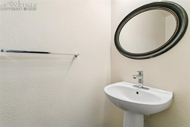 bathroom with a textured wall and a sink