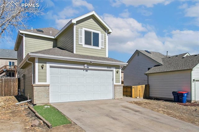 view of front facade with driveway, fence, and brick siding