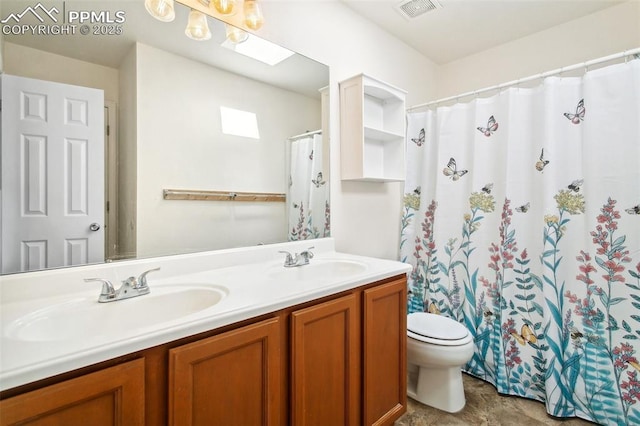 full bathroom with double vanity, a skylight, a sink, and visible vents