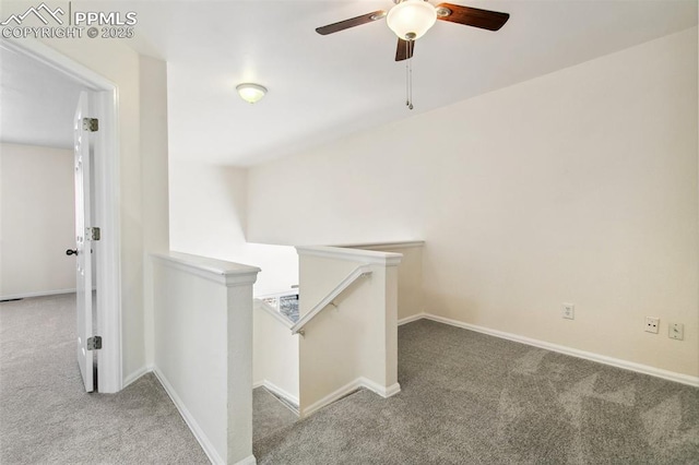 hall featuring baseboards, carpet flooring, and an upstairs landing