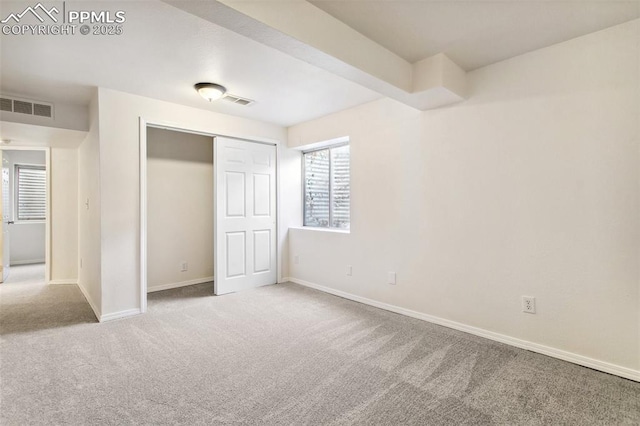 unfurnished bedroom featuring a closet, carpet flooring, visible vents, and baseboards