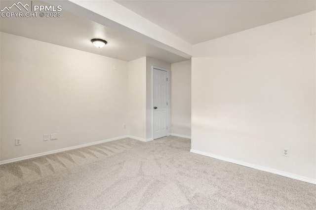 spare room featuring carpet floors and baseboards