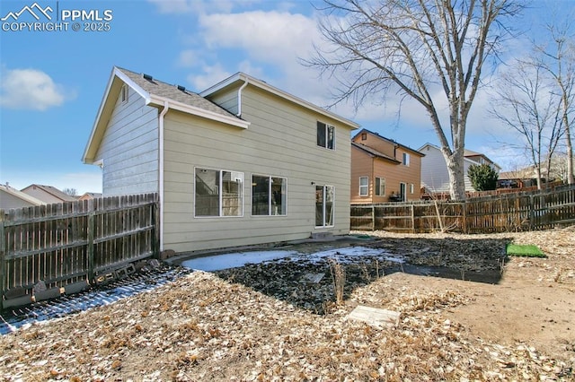 rear view of property with a fenced backyard