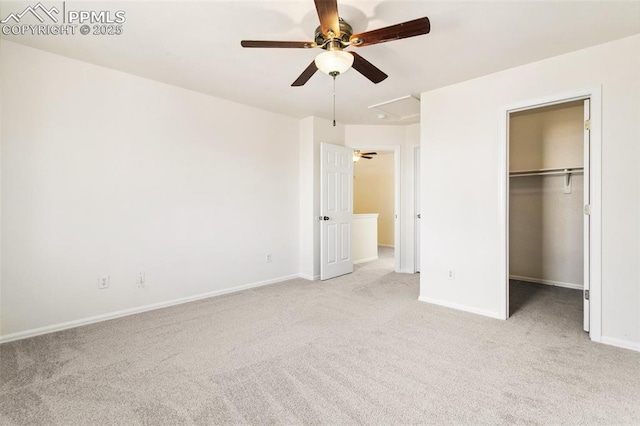 unfurnished bedroom with a spacious closet, baseboards, and light colored carpet