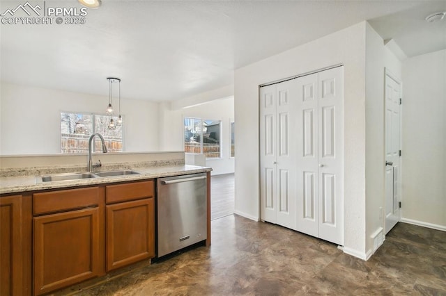 kitchen with a sink, light countertops, stainless steel dishwasher, hanging light fixtures, and plenty of natural light