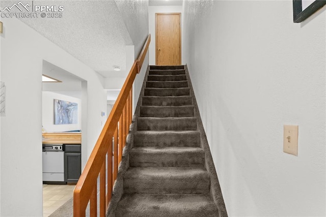 stairs featuring a textured ceiling