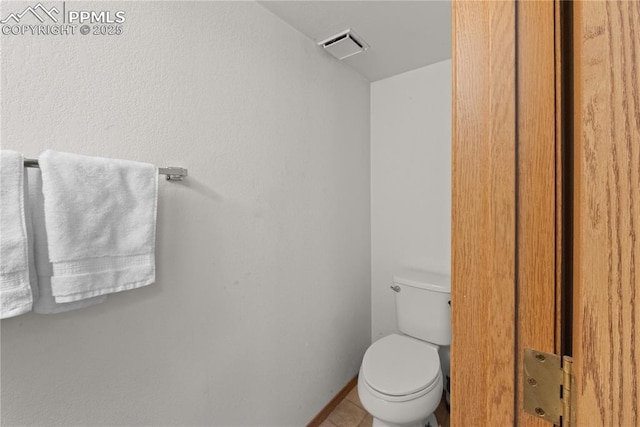 bathroom with toilet, tile patterned flooring, visible vents, and baseboards