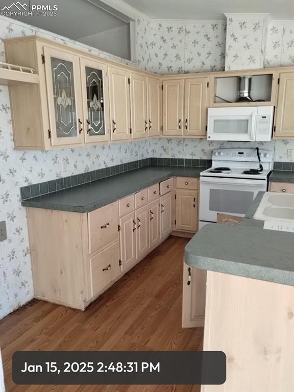 kitchen featuring dark countertops, white appliances, light wood-style flooring, and wallpapered walls