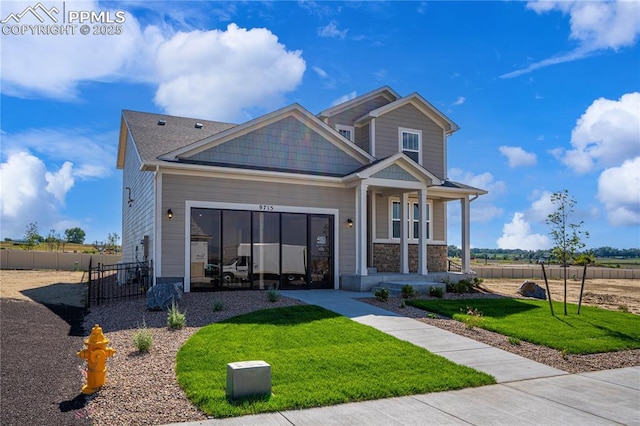 craftsman-style house featuring stone siding, covered porch, fence, and a front lawn