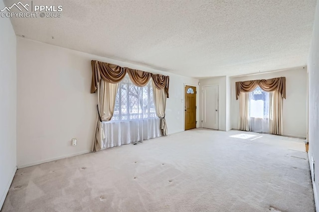 carpeted spare room featuring a textured ceiling and visible vents