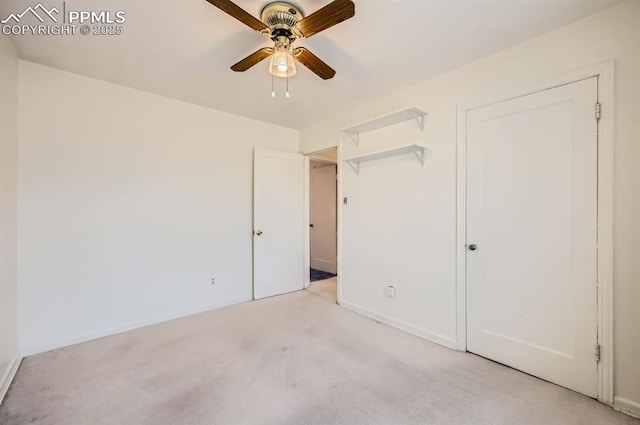 unfurnished bedroom featuring light carpet, a ceiling fan, and baseboards