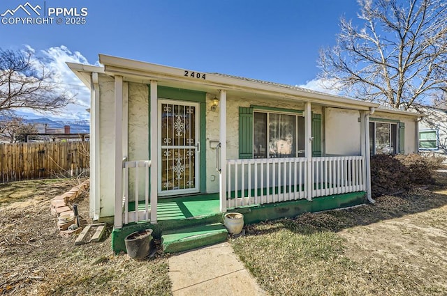 view of front of property featuring covered porch and fence