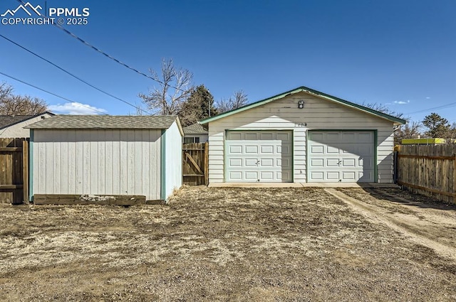 detached garage featuring fence