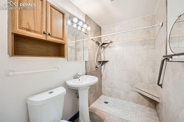 bathroom with toilet and a tile shower