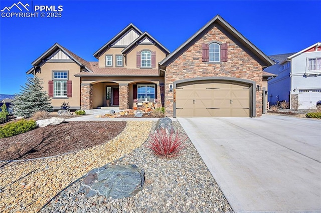 view of front of property featuring driveway, stone siding, and stucco siding