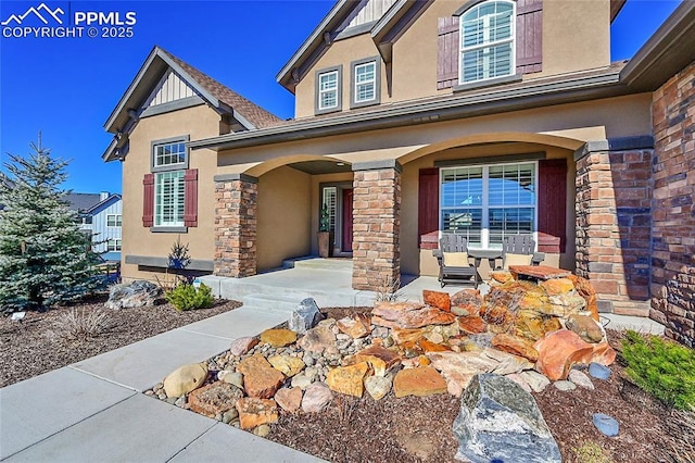 view of exterior entry featuring a porch and stucco siding