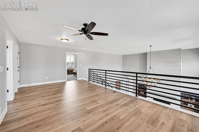 spare room featuring a ceiling fan, baseboards, and wood finished floors