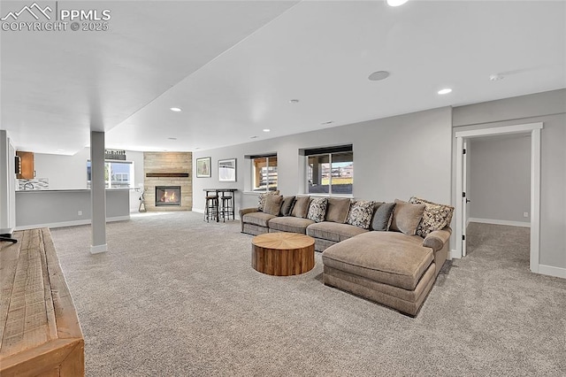 carpeted living room with a large fireplace, baseboards, and recessed lighting