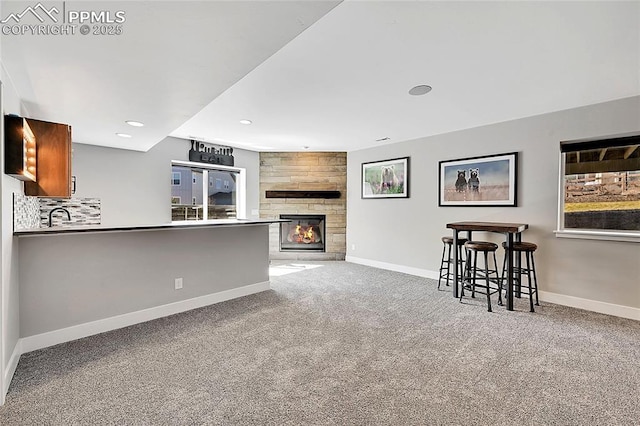 living room with carpet, a large fireplace, baseboards, and recessed lighting