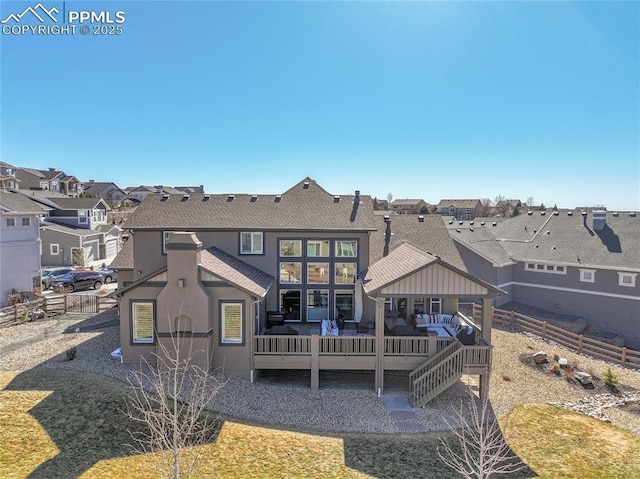 rear view of property with stucco siding, an outdoor hangout area, fence, a deck, and a residential view