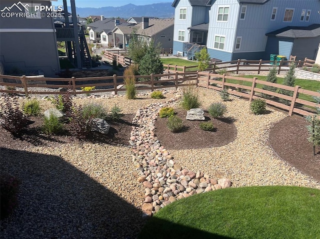 view of yard featuring a mountain view, fence, and a residential view