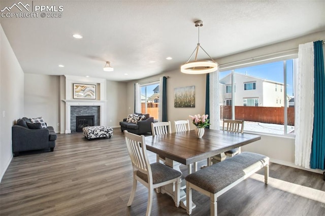 dining room with a fireplace, baseboards, wood finished floors, and recessed lighting