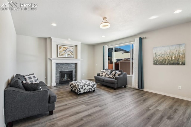 living room with recessed lighting, a fireplace, wood finished floors, and baseboards