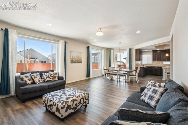 living area featuring plenty of natural light, baseboards, dark wood finished floors, and recessed lighting