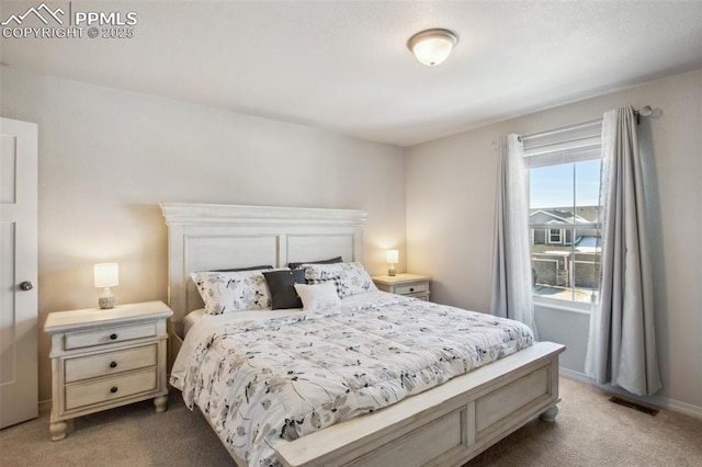 bedroom with carpet floors, visible vents, and baseboards