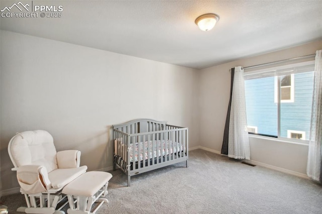 carpeted bedroom featuring a nursery area, multiple windows, and baseboards