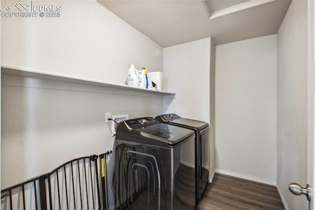 clothes washing area featuring laundry area, baseboards, washing machine and clothes dryer, and wood finished floors