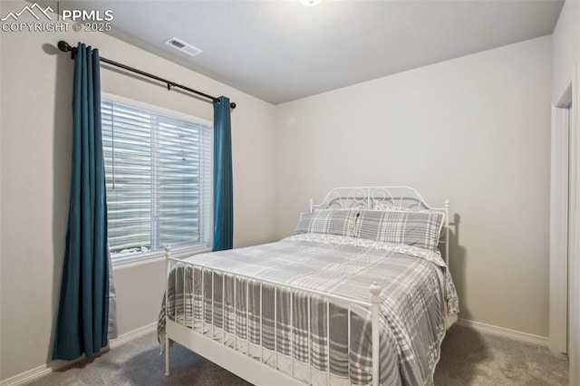 carpeted bedroom featuring visible vents, baseboards, and multiple windows