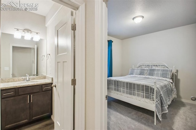 bedroom featuring a sink and baseboards