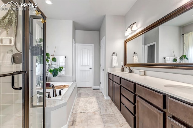 full bath featuring a bath, a shower stall, double vanity, and a sink