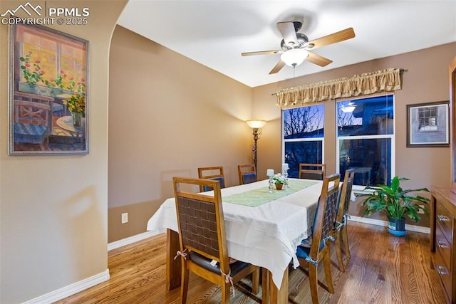 dining room with ceiling fan, wood finished floors, and baseboards