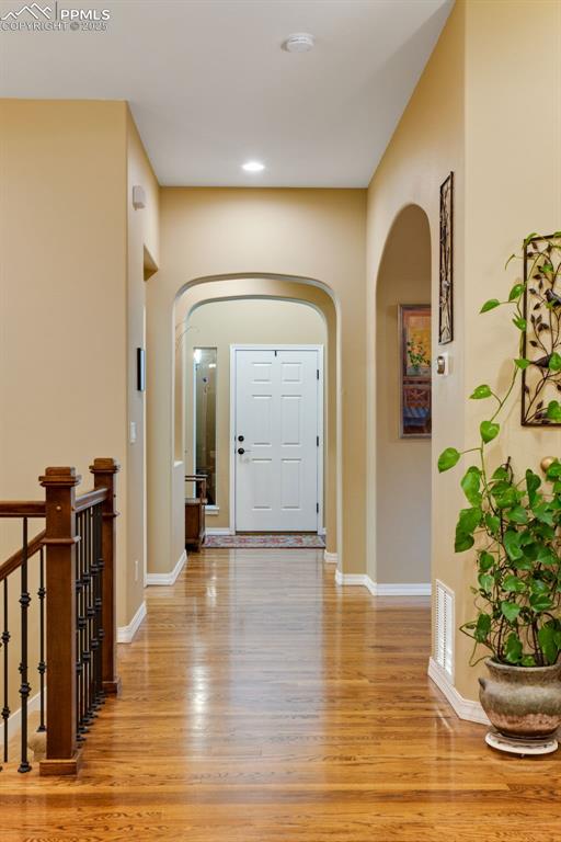 foyer featuring arched walkways, recessed lighting, visible vents, baseboards, and light wood finished floors