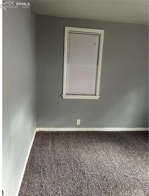 carpeted empty room featuring baseboards