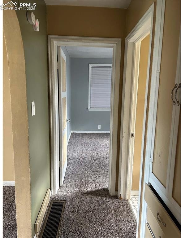hall featuring baseboards, visible vents, and carpet