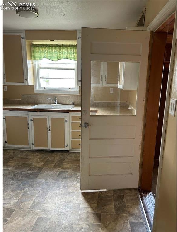 kitchen with stone finish flooring and a sink