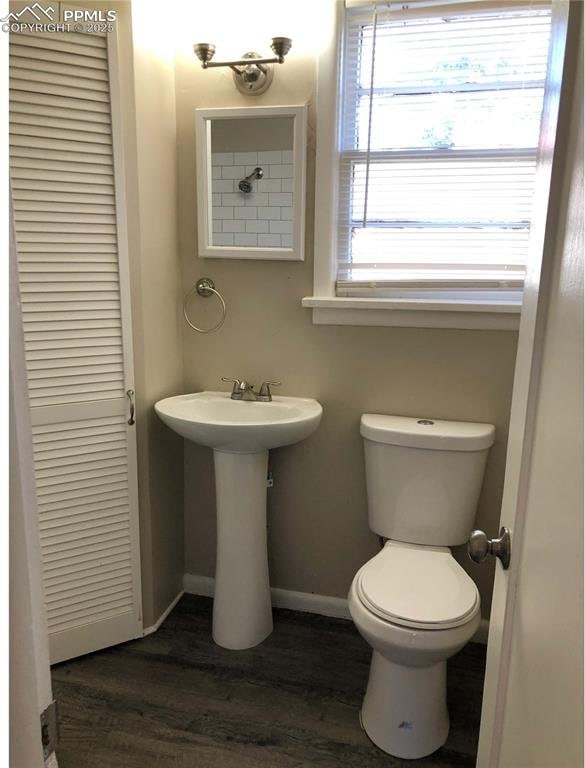 bathroom featuring wood finished floors, baseboards, a sink, and toilet