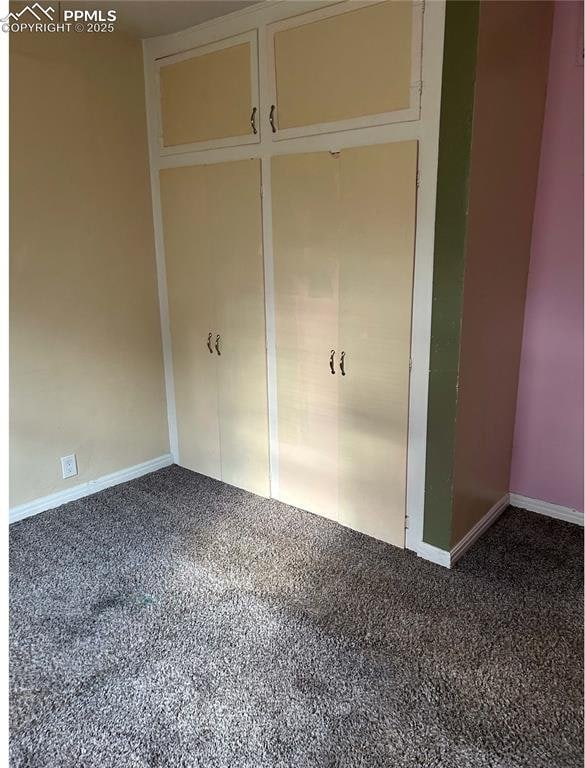 unfurnished bedroom featuring baseboards and carpet
