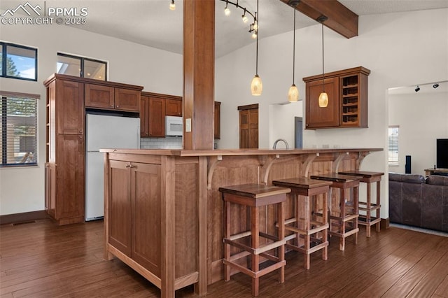 kitchen featuring high vaulted ceiling, white appliances, dark wood-type flooring, and beam ceiling