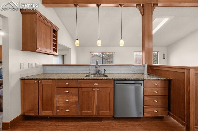 kitchen with vaulted ceiling with beams, brown cabinets, a sink, and stainless steel dishwasher