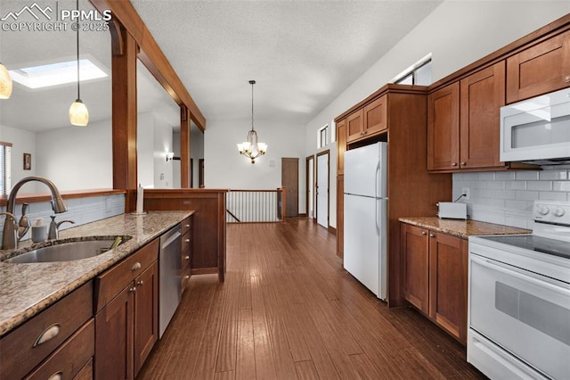 kitchen featuring dark wood-type flooring, white appliances, a sink, decorative backsplash, and brown cabinetry