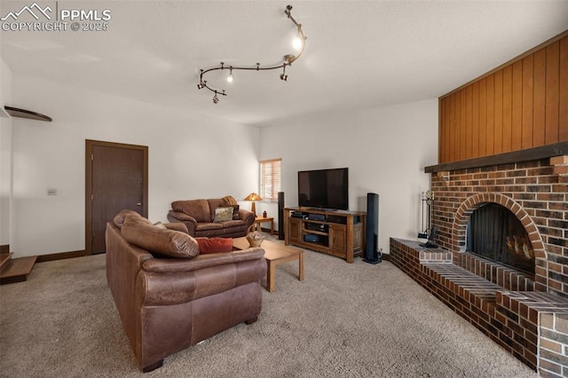 living area featuring rail lighting, a fireplace, and light colored carpet