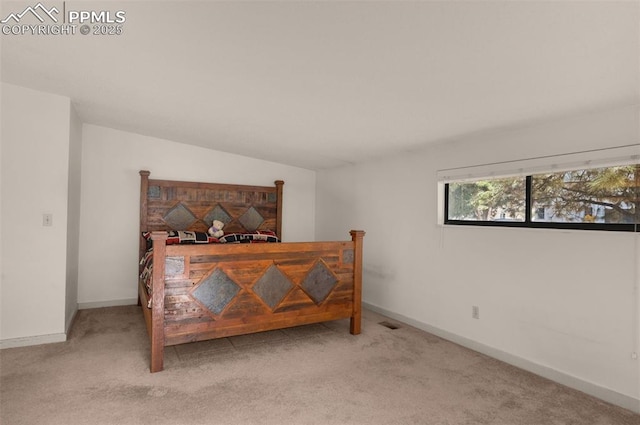 bedroom with lofted ceiling, carpet flooring, and baseboards