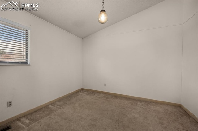 unfurnished room with carpet, visible vents, vaulted ceiling, and baseboards