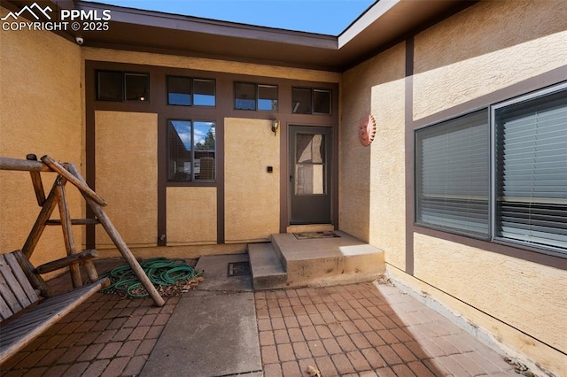 view of exterior entry featuring stucco siding