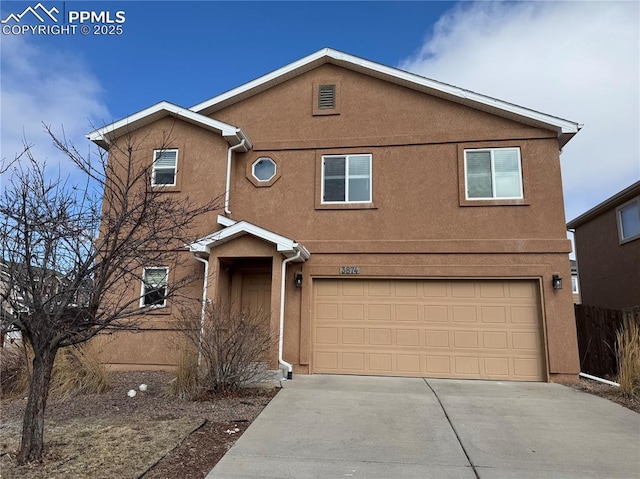 traditional home featuring driveway, an attached garage, and stucco siding