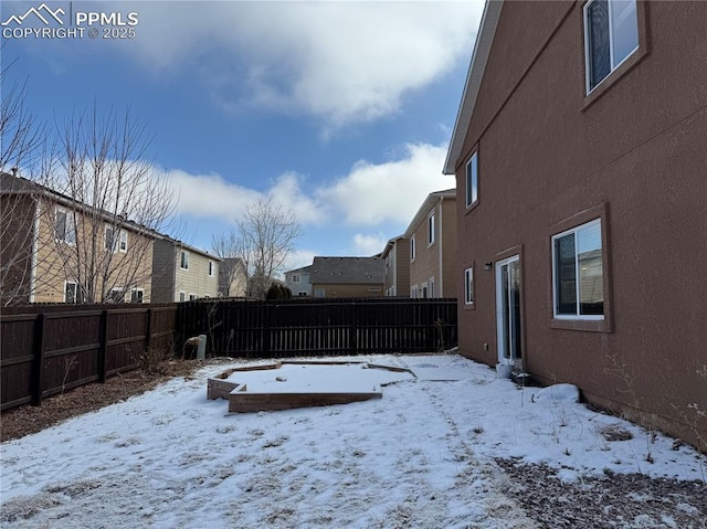 snowy yard with a fenced backyard and a residential view